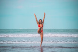 Young woman in red bikini having fun in turquoise sea