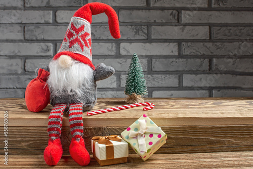 Cute Christmas gnome and festive decor on table. Space for text