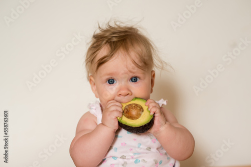 Little child eats an avocado