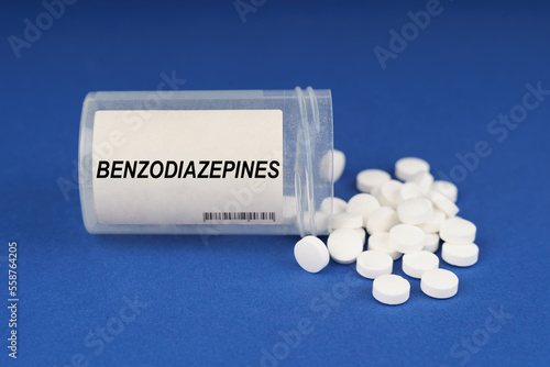 Foto On a blue surface are pills and a dusty jar with the inscription - Benzodiazepin