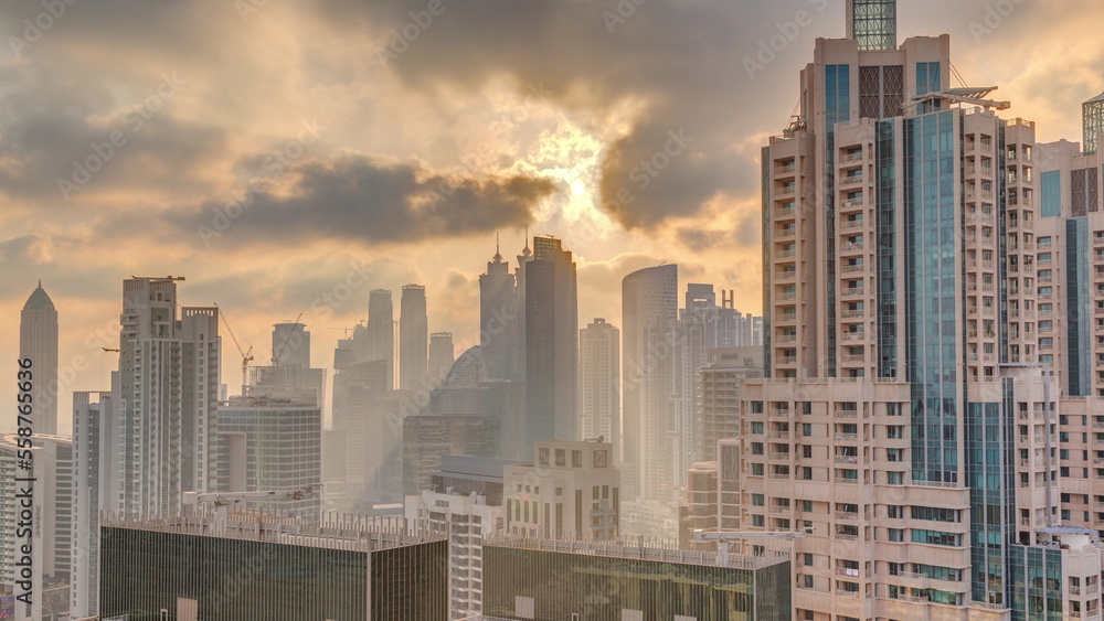 Dubai skyscrapers with golden sunset over business bay district timelapse.