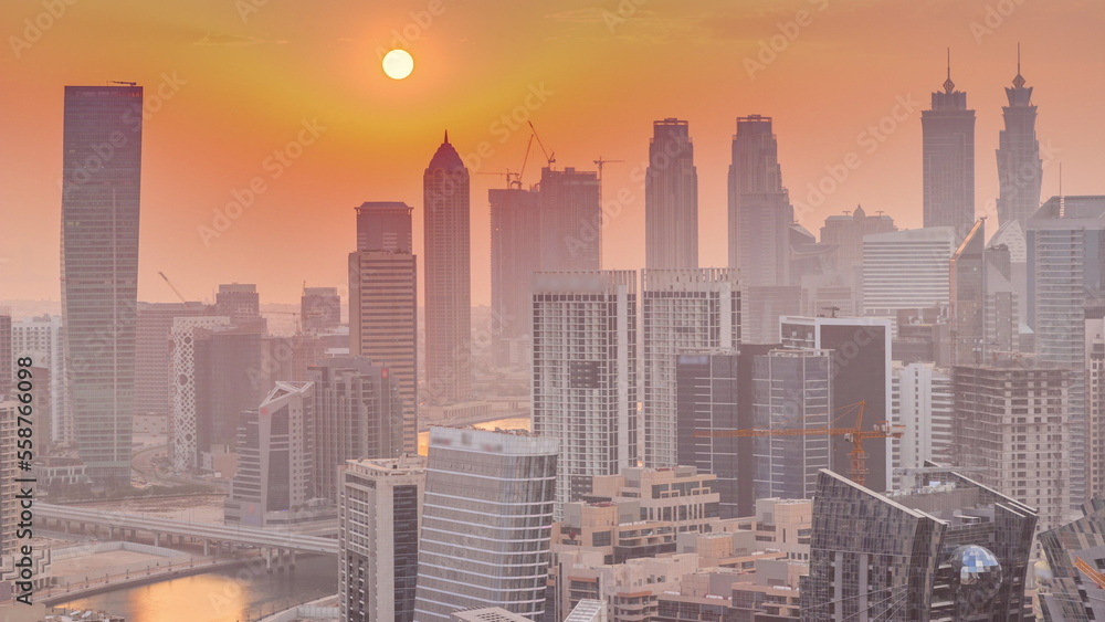 Fototapeta premium Skyline with modern architecture of Dubai business bay towers at sunset timelapse. Aerial view