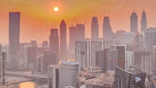 Skyline with modern architecture of Dubai business bay towers at sunset timelapse. Aerial view