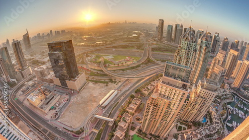 Sunrise over Dubai marina and JLT skyscrapers along Sheikh Zayed Road aerial timelapse.
