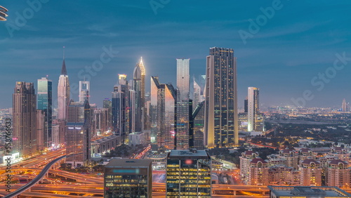 Panorama of Dubai Financial Center district with tall skyscrapers with illumination day to night timelapse.