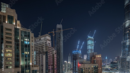 Panorama showing aerial cityscape night timelapse with illuminated architecture of Dubai downtown.