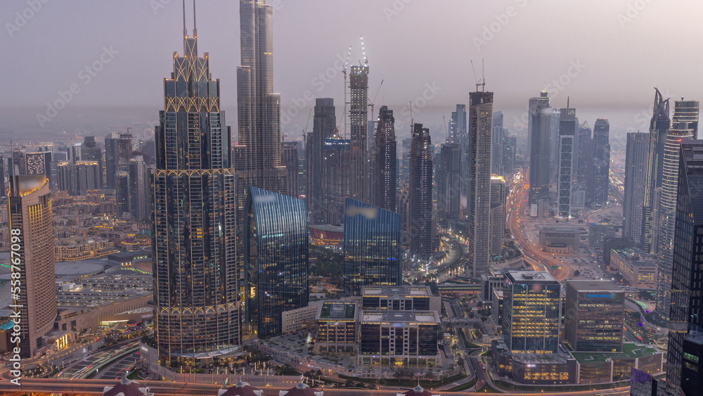 Obraz premium Aerial view of tallest towers in Dubai Downtown skyline and highway day to night timelapse.