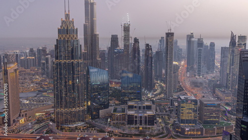 Aerial view of tallest towers in Dubai Downtown skyline and highway day to night timelapse.