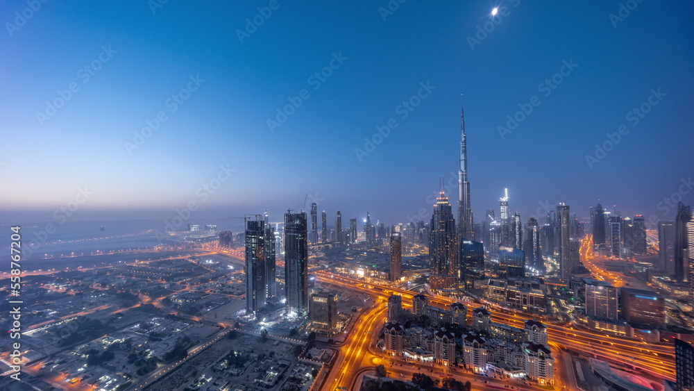 Aerial view of tallest towers in Dubai Downtown skyline and highway night to day timelapse.