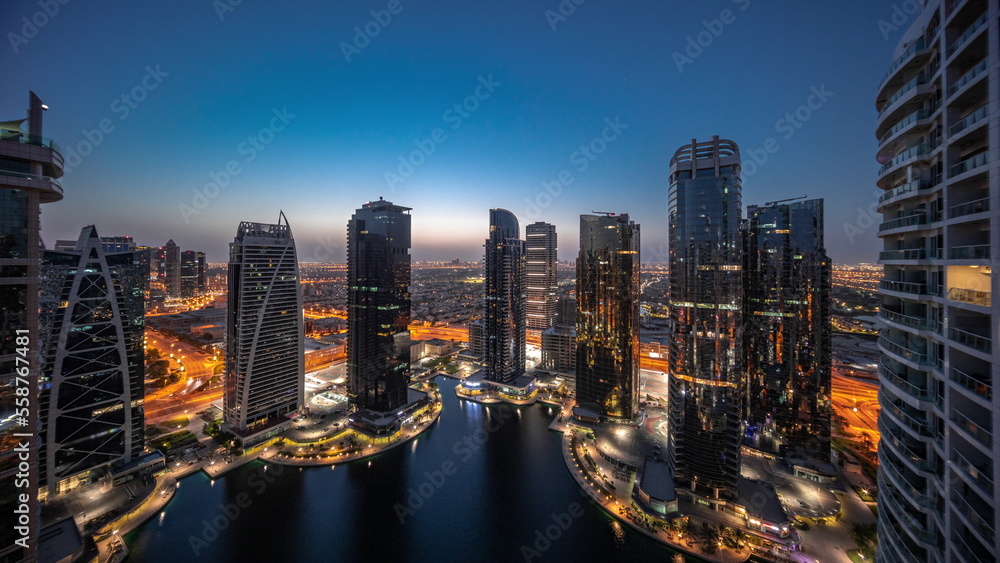Tall residential buildings at JLT aerial night to day timelapse, part of the Dubai multi commodities centre mixed-use district.