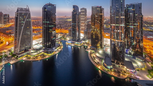 Tall residential buildings at JLT aerial night to day timelapse  part of the Dubai multi commodities centre mixed-use district.