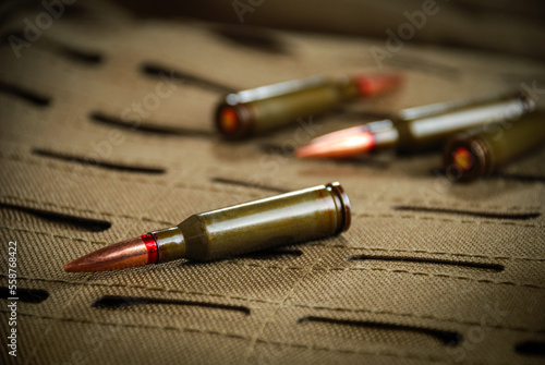 Several cartridges for a rifle lie on a tactical backpack made of durable fabric Cordura.