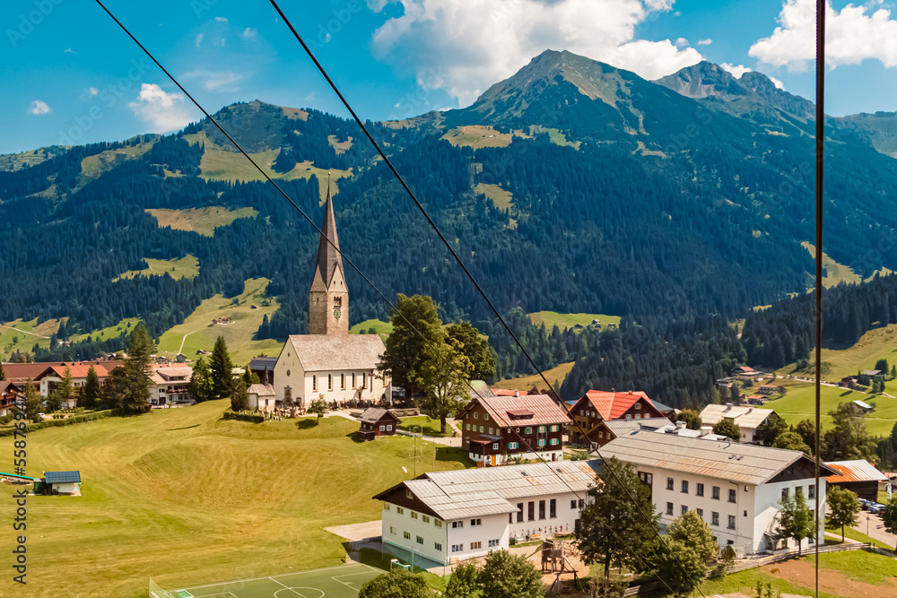 Fototapeta premium Beautiful aerial summer view of Mittelberg with a church, Kleinwalsertal valley, Vorarlberg, Austria