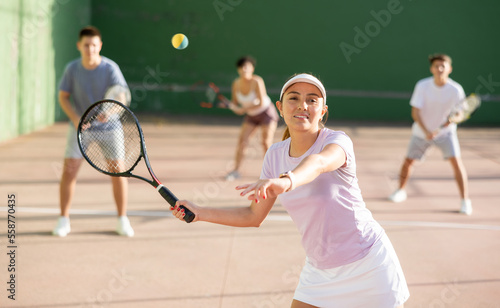 Expressive resolved fit girl playing frontenis ball friendly match on outdoors court © JackF