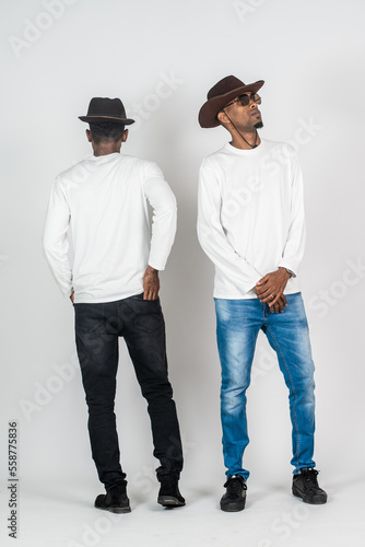 Two african man wearing white blank long sleeve shirt, doing a pose with one of them turning back and the other on the front side