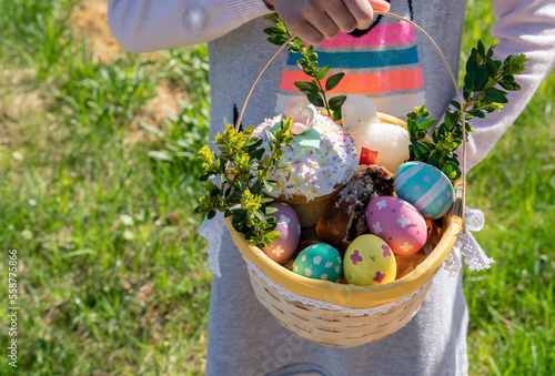 Children holds easter basket with eggs and bread