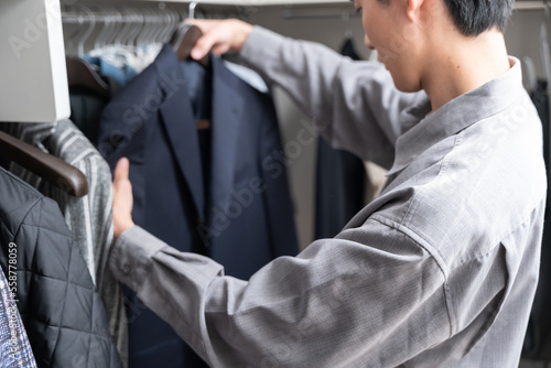 Foto ウォークインクローゼットで服を選ぶ若い男性（ファッション・コーディネート）