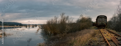 Panoramic landscape of sunset on the lake. Old train on the railway beside the marshes. Northern Ireland UK