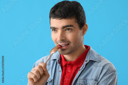Young man with tablespoon o...