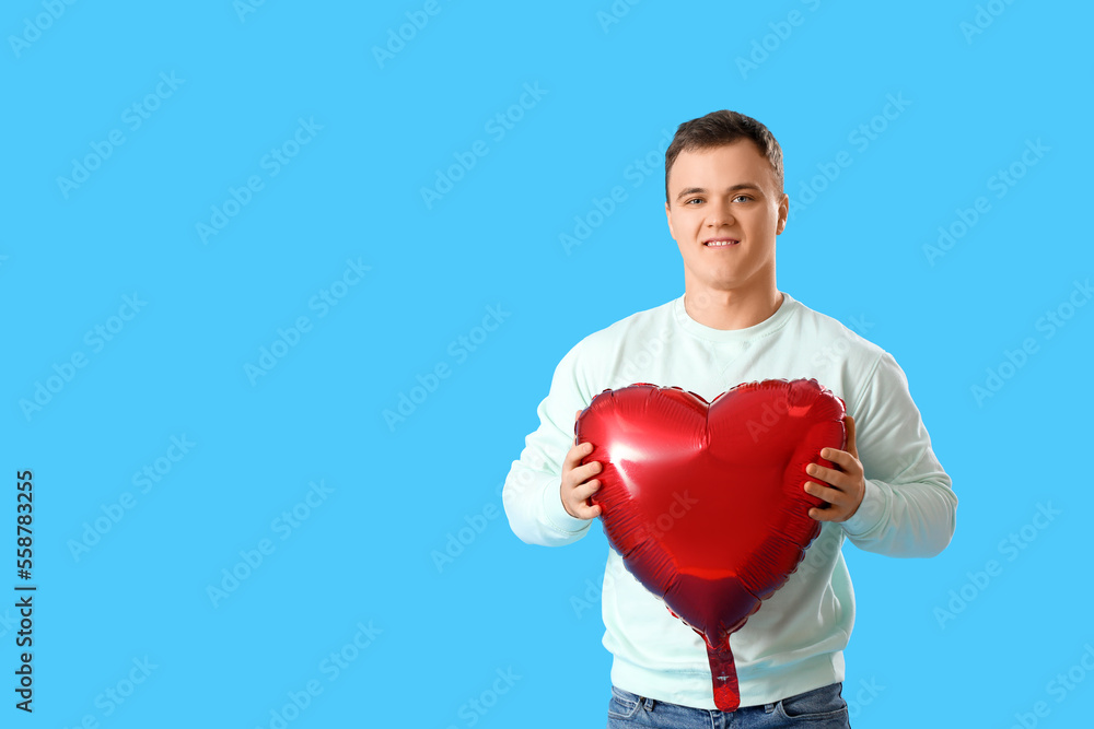 Young man with balloon for Valentine's Day on blue background Young man with balloon for Valentine's Day on blue background