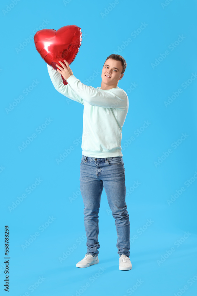 Young man with balloon for Valentine's Day on blue background Young man with balloon for Valentine's Day on blue background