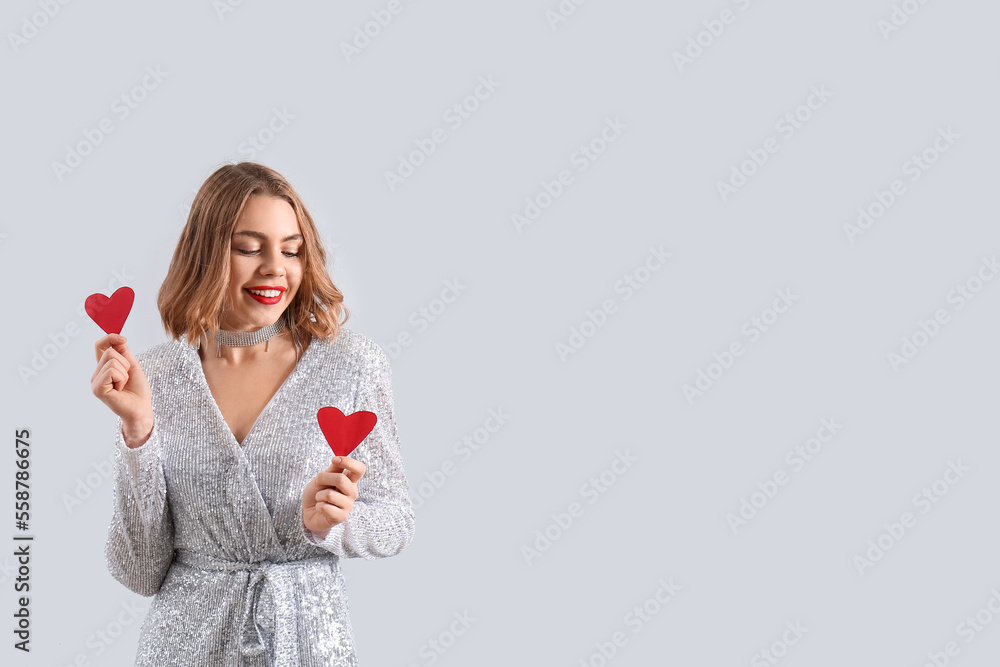 Beautiful young woman with small red hearts on light background Beautiful young woman with small red hearts on light background