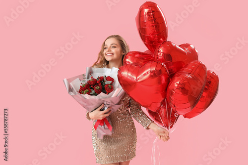 Happy young woman with heart-shaped balloons and flowers on pink background. Valentine's Day celebration