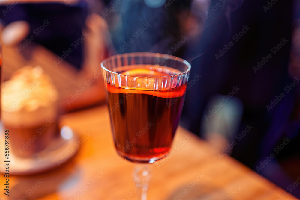 Christmas mulled wine or gluhwein with spices with hot steam, traditional drink on winter holiday, selective focus Christmas mulled wine or gluhwein with spices with hot steam, traditional drink on winter holiday, selective focus