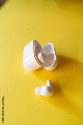 Top down view of wireless earbuds headphone on the yellow background