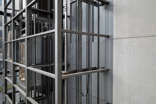 Exterior view at open system and modern industrial style of elevator with steel cage grid frame structure.