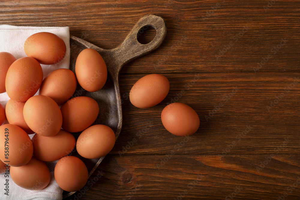 Raw brown chicken eggs on wooden table, flat lay. Space for text Raw brown chicken eggs on wooden table, flat lay. Space for text