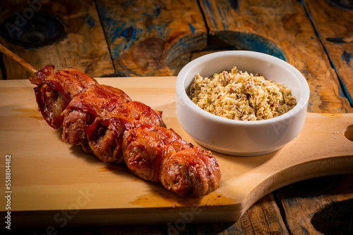 Espetinho de churrasco com farofa em tábua de madeira