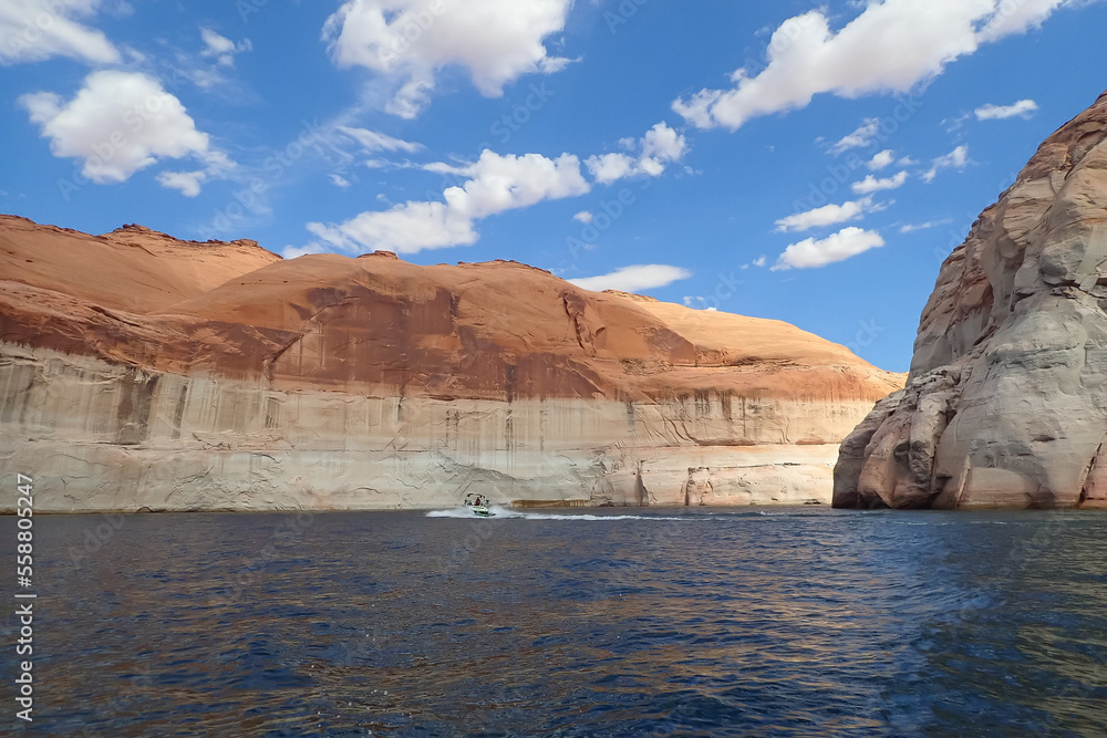 Colorful sandstone rock formations and boat on the Colorado River at Glen Canyon National Recreation Area