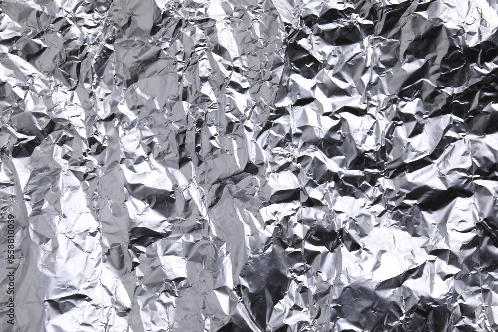 Crumpled silver foil as background, closeup view Crumpled silver foil as background, closeup view