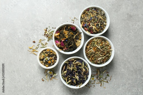 Flat lay composition with different dry teas on light grey table