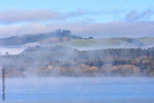 Morning fog covering water surface and shores around Lake Taupo. Location: Taupo New Zealand