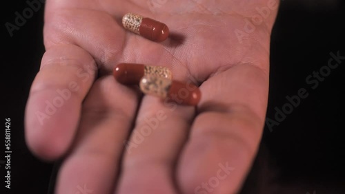 Wallpaper Mural The man opens his hand and there are a lot of pills: enzyme, pancreatic treatment. Close-up shot on a black surface. Torontodigital.ca