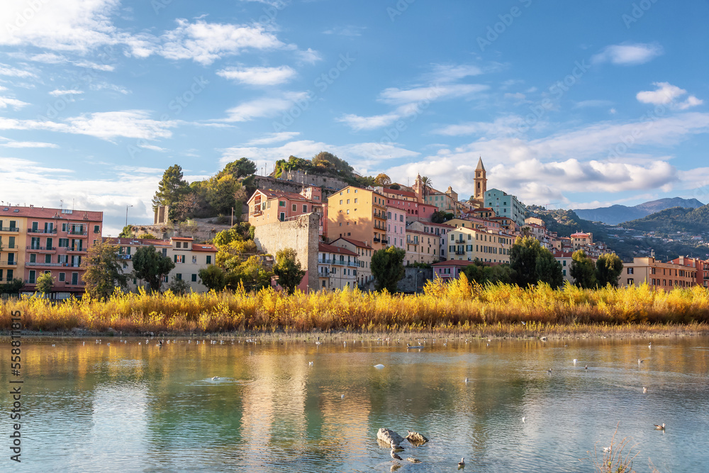 Obraz premium Old Residential Homes near river and sea in Ventimiglia, Italy. Sunny Fall Season.