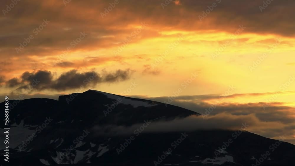 View on a distant summit of Snohetta mountain in Dovrefjell National Park. Summer in Norway. Beautiful sunset sky. View on a distant summit of Snohetta mountain in Dovrefjell National Park. Summer in Norway. Beautiful sunset sky.
