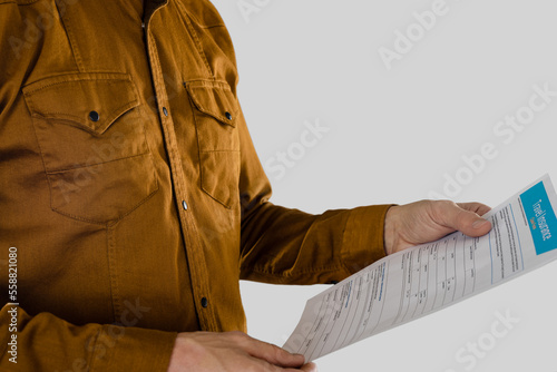 Man in the studio on a light gray background holding travel insurance claim form for filling
