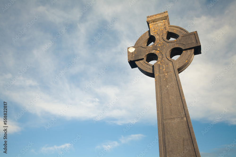Irish Culture, Travel concept. Stone monument of Christian Cross in Bruff, County Limerick, Ireland. Blue sky background. Copy-space. Outdoor shot Irish Culture, Travel concept. Stone monument of Christian Cross in Bruff, County Limerick, Ireland. Blue sky background. Copy-space. Outdoor shot