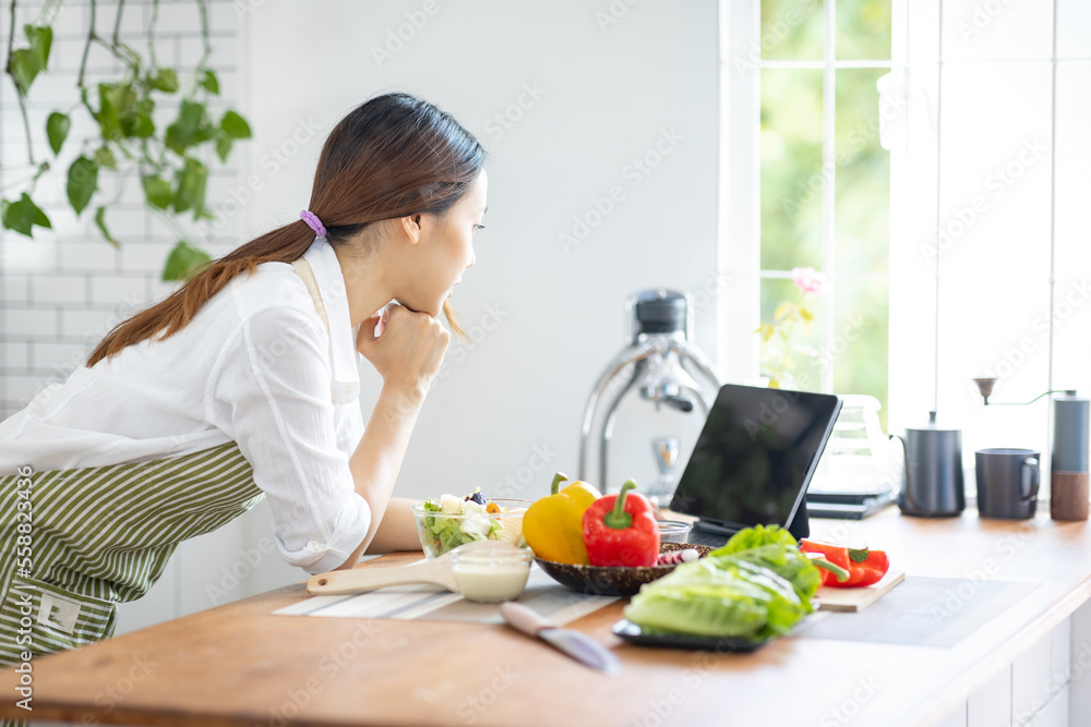 Portrait of attractive asian japanese woman in kitchen at home, young girl browsing website on tutor cooking class and doing for kitchen, cutting vegetables, cooking, cooking concept. Portrait of attractive asian japanese woman in kitchen at home, young girl browsing website on tutor cooking class and doing for kitchen, cutting vegetables, cooking, cooking concept.