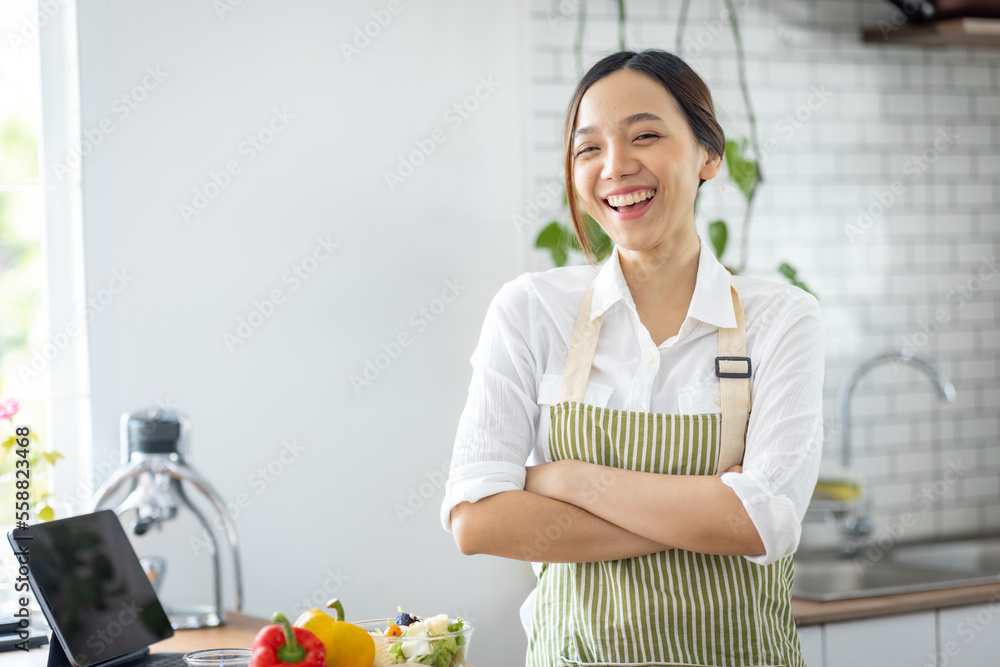 Portrait of attractive asian japanese woman in kitchen at home, young girl browsing website on tutor cooking class and doing for kitchen, cutting vegetables, cooking, cooking concept. Portrait of attractive asian japanese woman in kitchen at home, young girl browsing website on tutor cooking class and doing for kitchen, cutting vegetables, cooking, cooking concept.