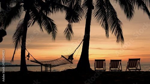 Hammock and beach chairs on the beach with palm trees during sunset at Na Jomtien Beach Pattaya Thailand. photo