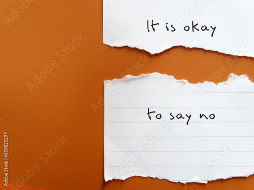 Torn ripped paper on brown rough texture background IT IS OKAY TO SAY NO, means no one can make everyone happy, Stop people pleasing, be true and comfortable to say no when you want to