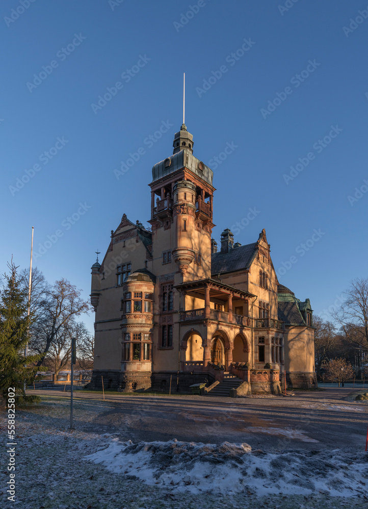 Old castle looking building with towers on the island Djurgården a low winter solstice a sunny and snowy day in Stockholm