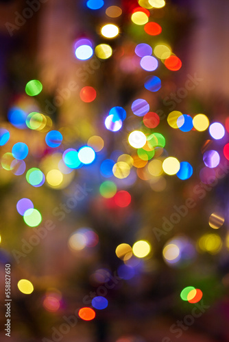 Close-up of the bokeh of a Christmas tree inside the room.