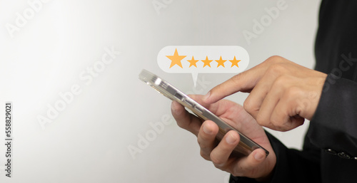 Customer hand pressing on smartphone screen 5 star satisfaction rating, service business concept.