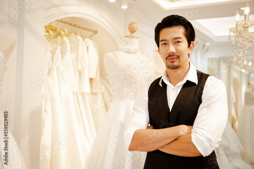 Asian handsome man bridal store owner work in wedding studio shop. Owner Of Bridal Wedding Dress Shop Work in shop.