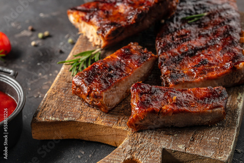 Barbecue chuck beef ribs with hot rub sliced on a wooden cutting board, Food recipe background. Close up